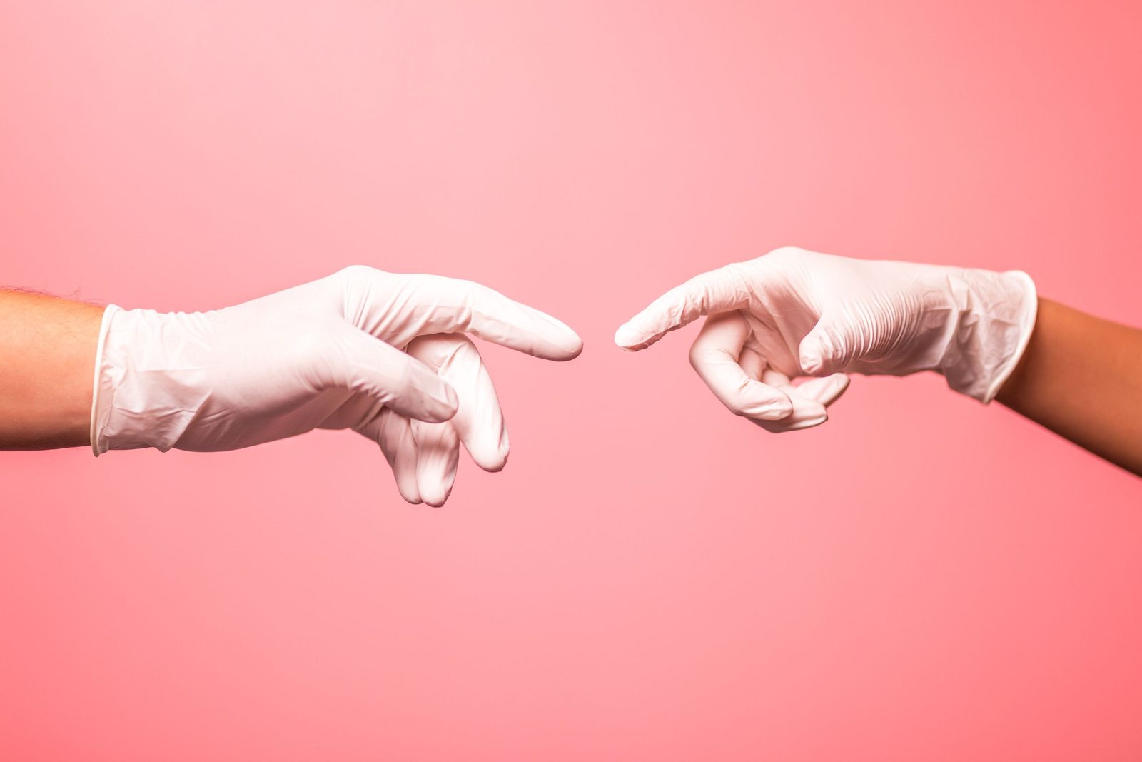 Two gloved hands reaching toward each other, illustrating glove-to-glove contact precautions